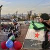 Une femme tenant un drapeau syrien, le 21 janvier 2025. (BILAL ALHAMMOUD / Middle East Images via AFP)